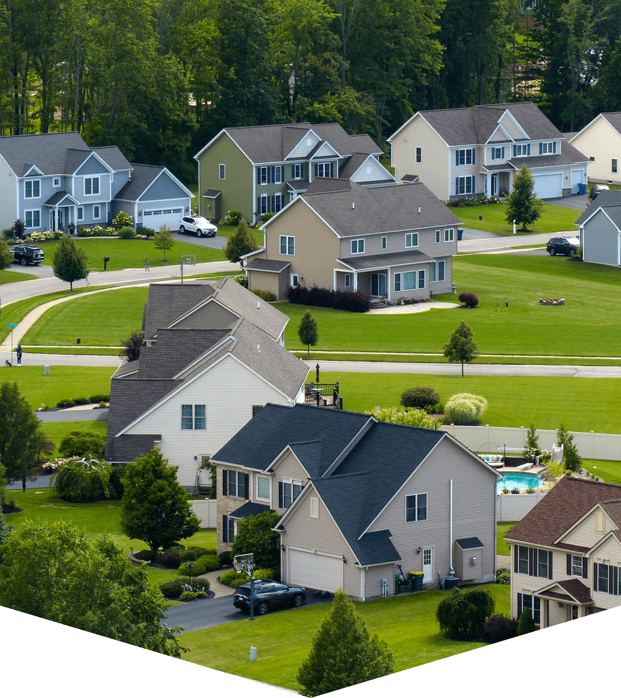 A view of houses from above with trees in the background.