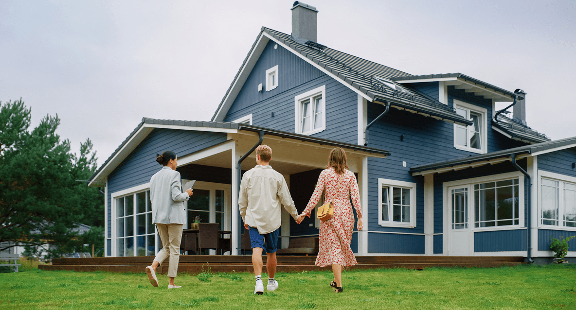 A group of people walking in front of a house.
