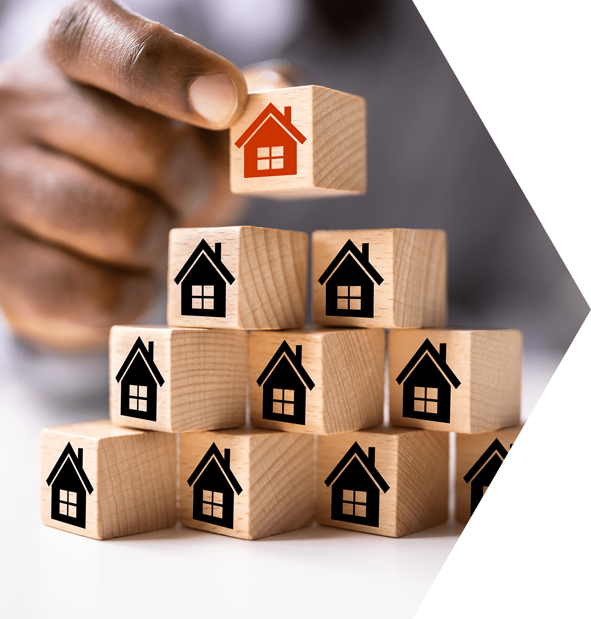 A person is stacking blocks with houses on them.